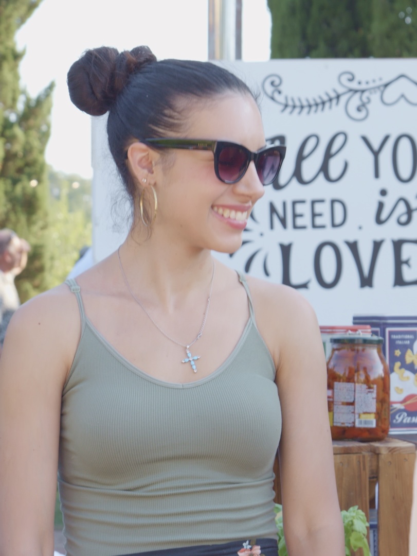 A guest smiling in front of our All you need is love sign