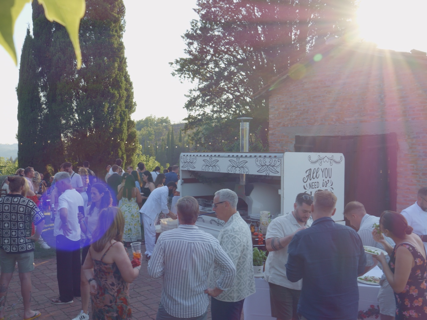 Guests gathered around the pizza truck at golden hour