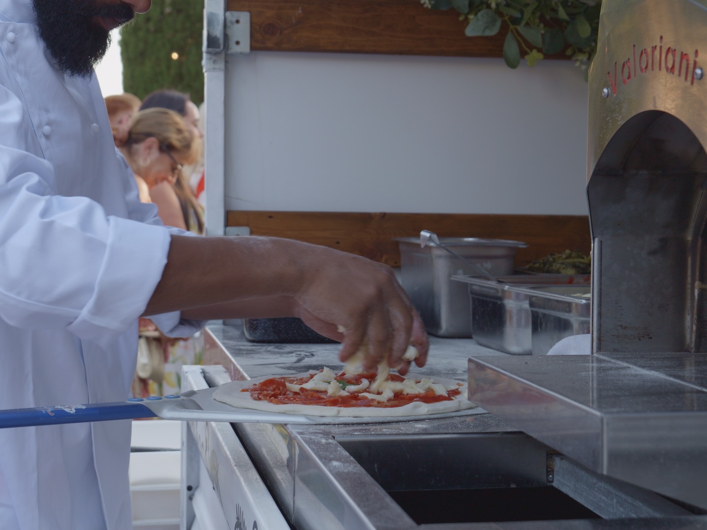 Our pizzaiolo topping a Neapolitan pizza beside the gas oven
