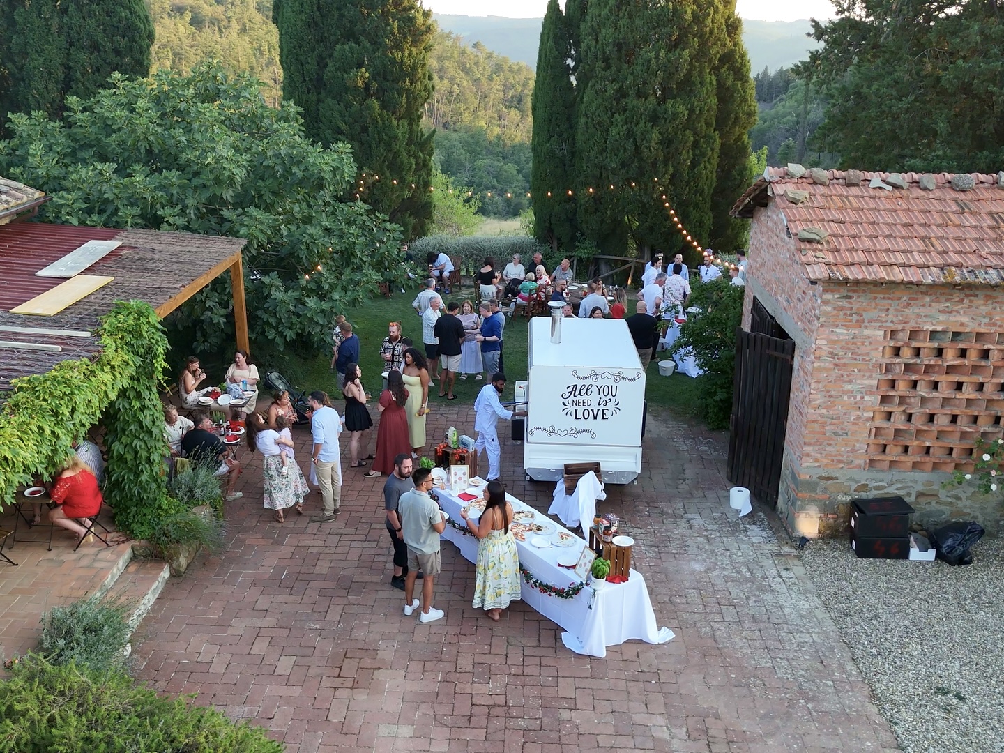 Aerial view of the Mamma Mia Pizza Party truck and guests at a Tuscan villa