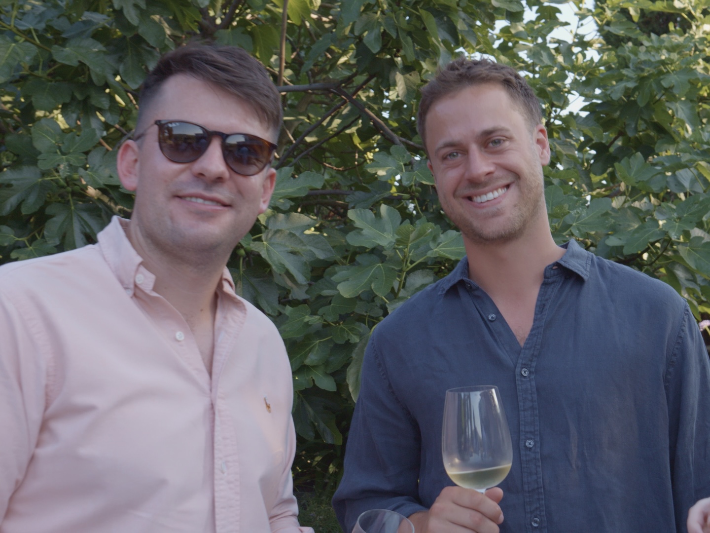 Two guests smiling with drinks in the villa garden
