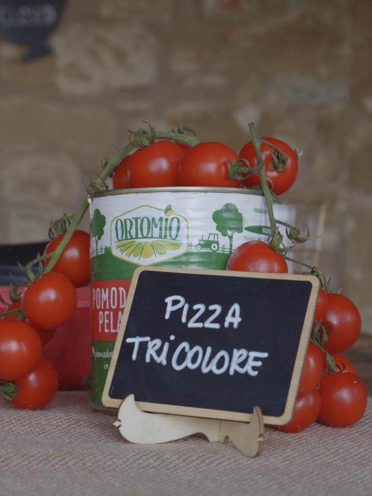 Fresh cherry tomatoes around a Pizza Tricolore menu card