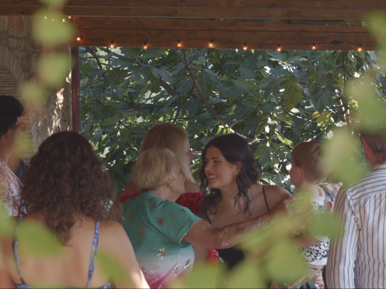 Guests hugging and laughing under the festoon lights