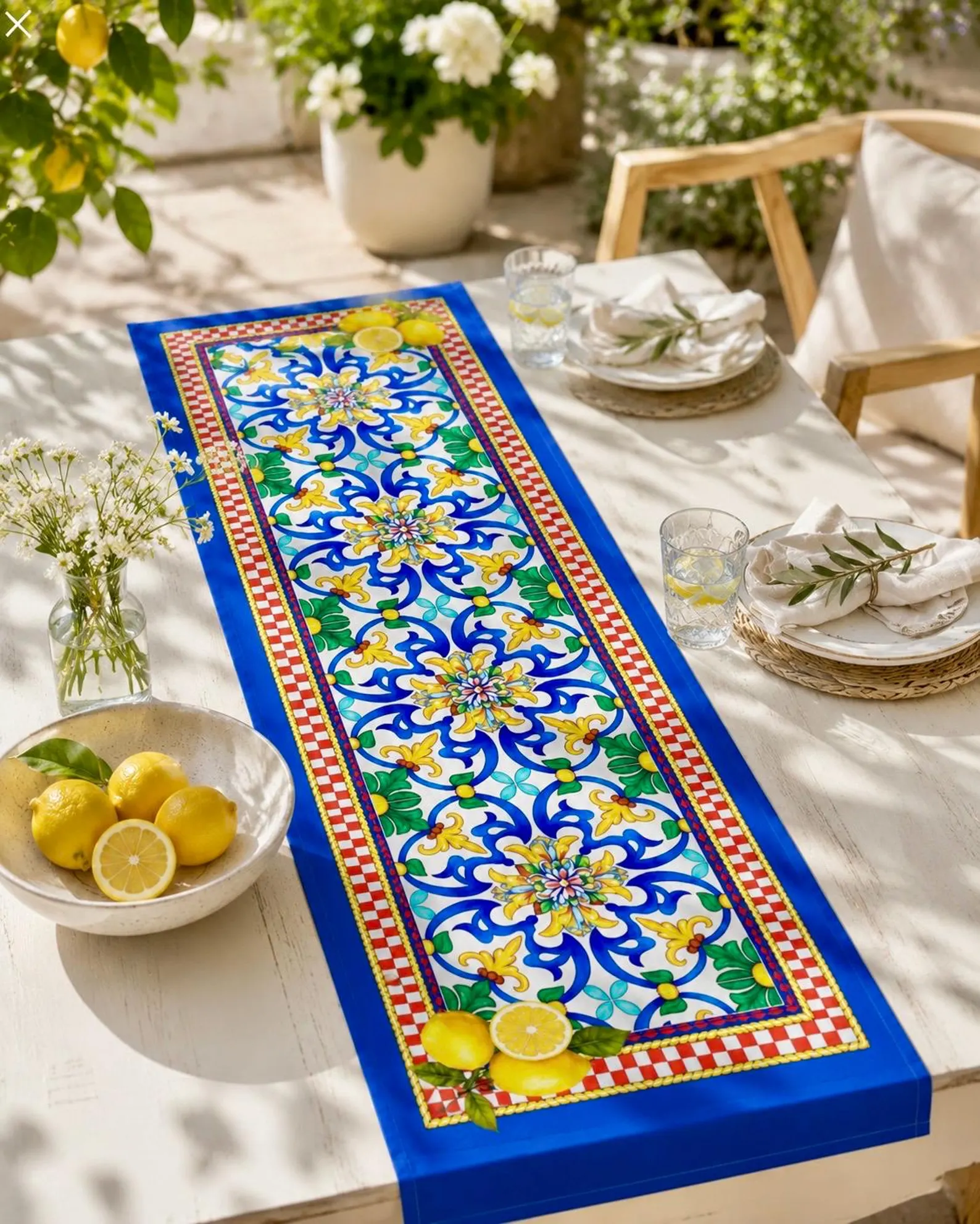 Outdoor table set with a blue and yellow Amalfi majolica runner and fresh lemons
