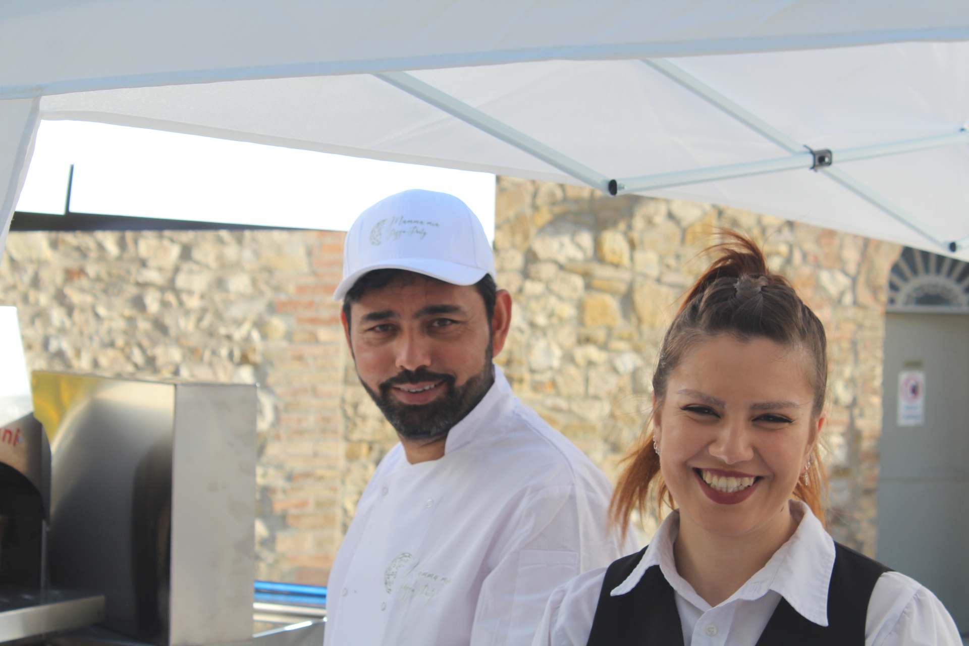 Guests queuing at the Mamma Mia Pizza Party truck during an evening event in Tuscany