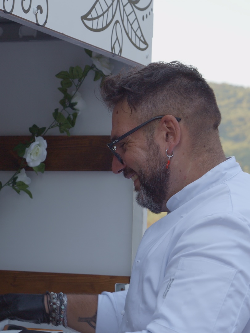 Our pizzaiolo smiling while preparing pizzas at the truck