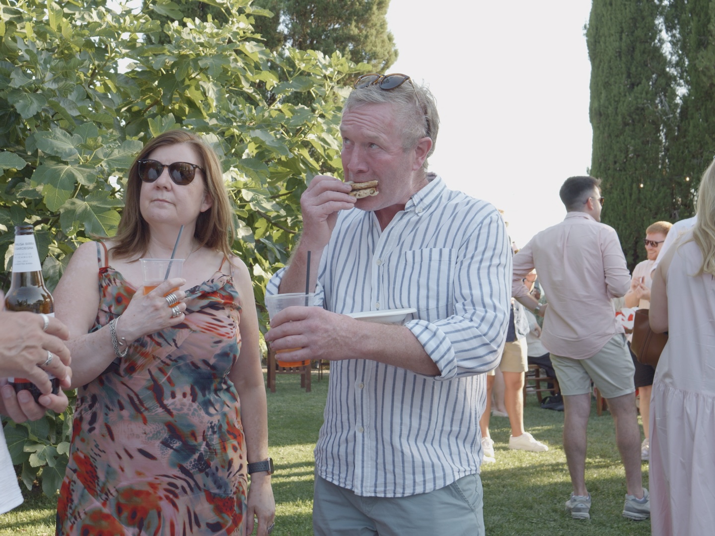 A large group of wedding guests being served pizza outdoors in Tuscany