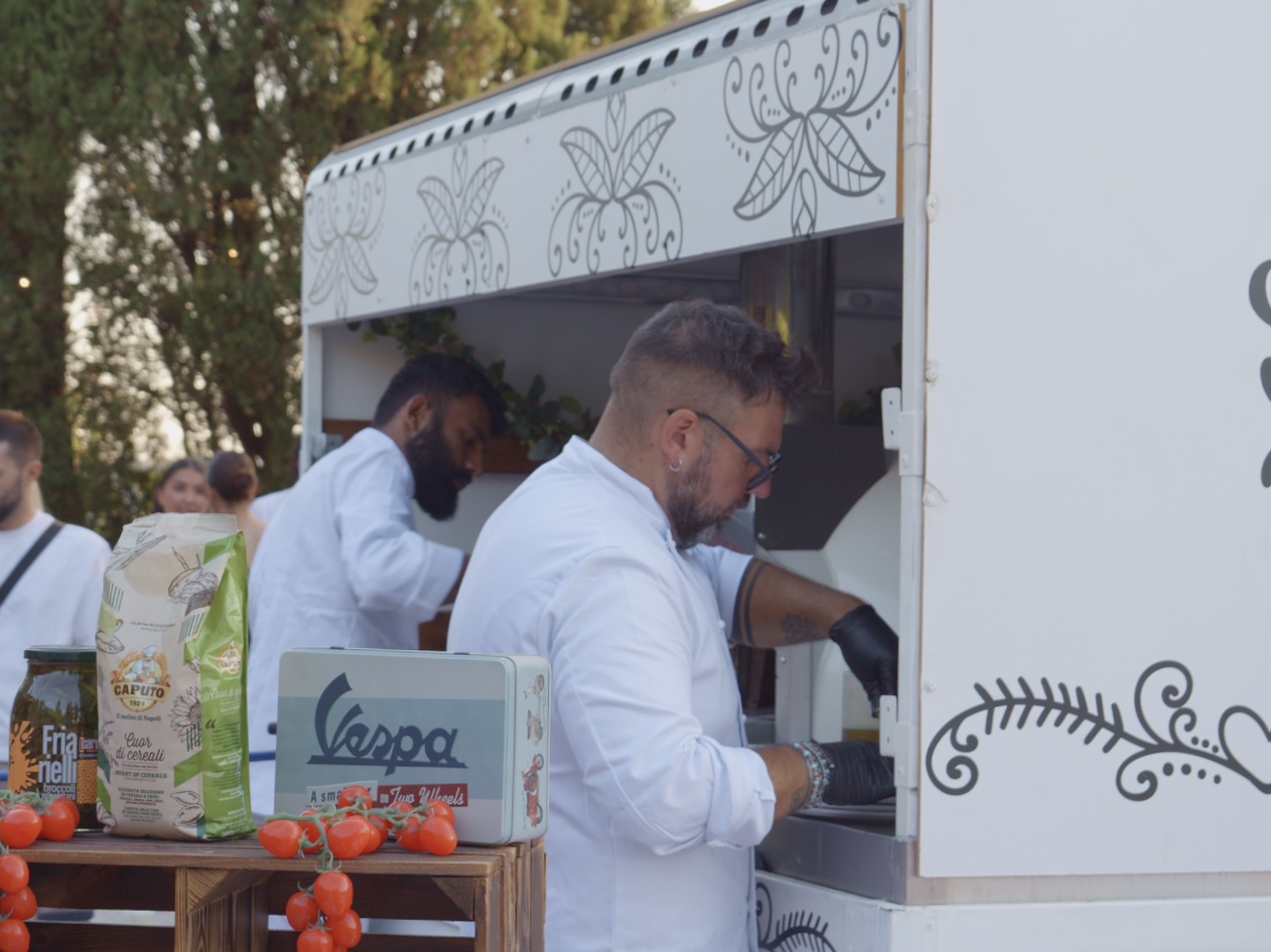 Guests helping themselves to Neapolitan pizza at a relaxed lunch in Tuscany