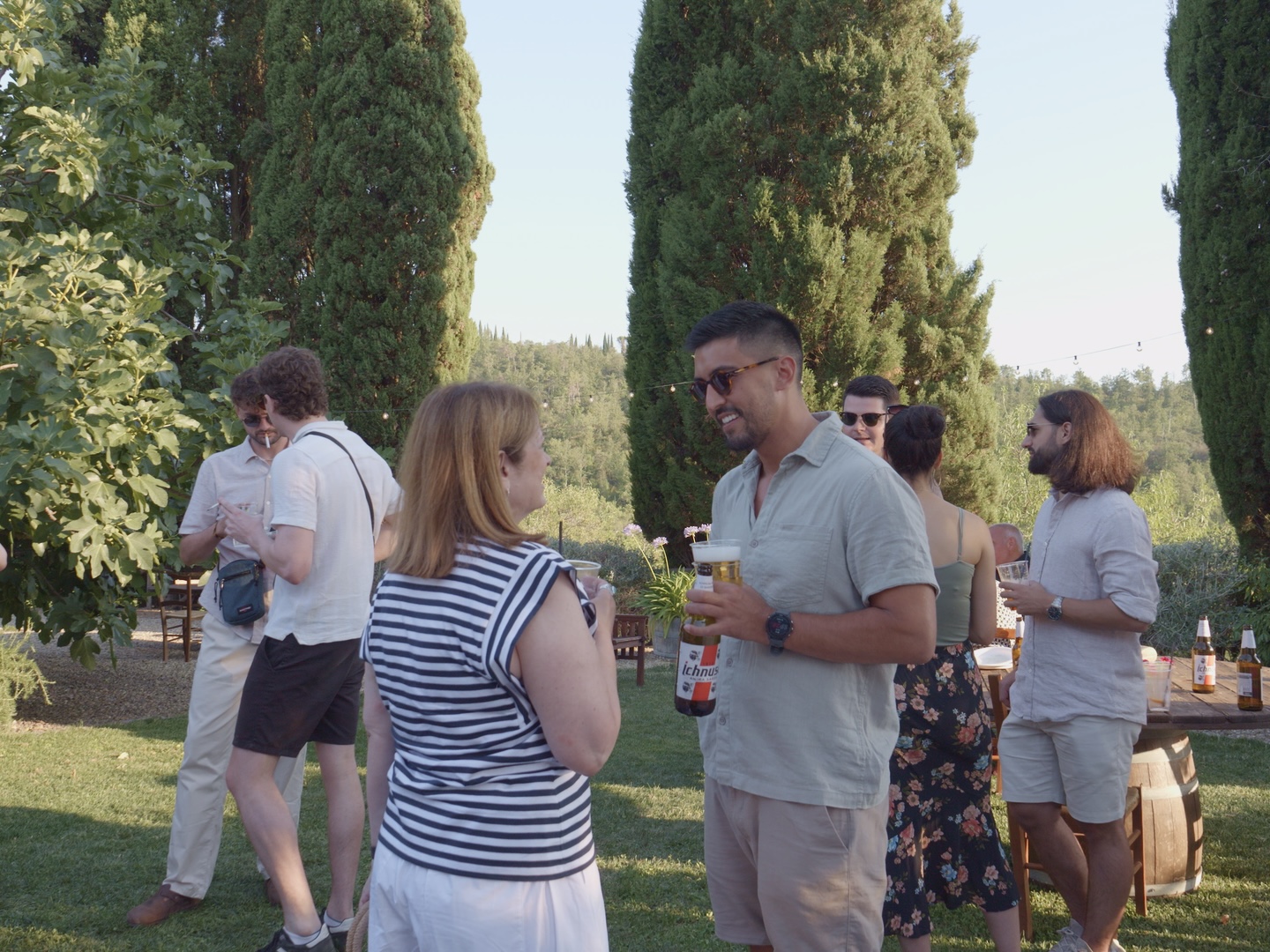 A guest holding a freshly baked Neapolitan pizza at an outdoor wedding in Tuscany