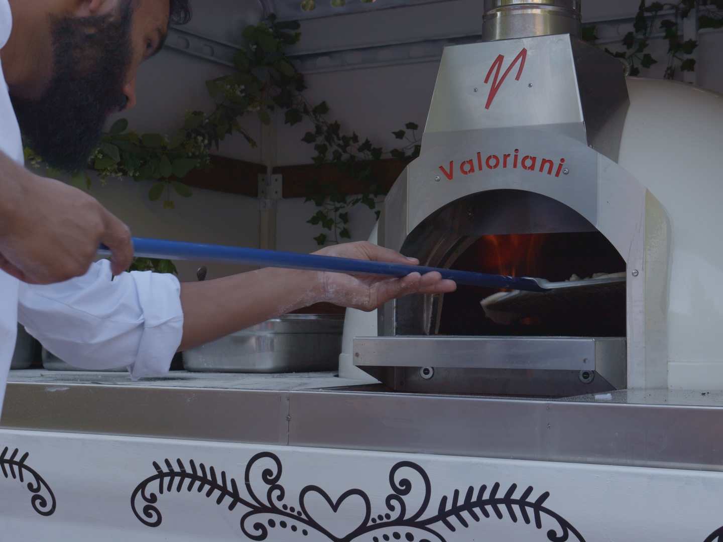 Our pizzaiolo sliding a pizza into the gas oven inside the truck